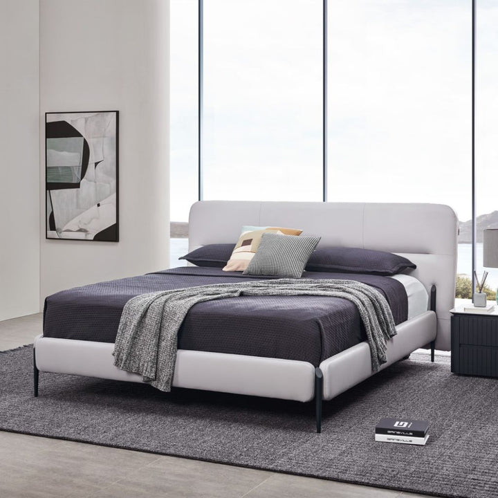 Odessa Bed with a minimalist angled headboard and satin black metal legs in a modern bedroom